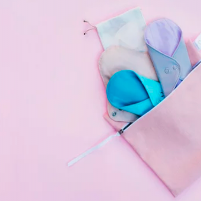 pensos reutilizáveis coloridos em bolsa rosa sobre fundo rosa