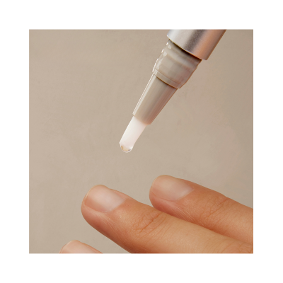 Caneta aplicadora pingando líquido transparente nas unhas