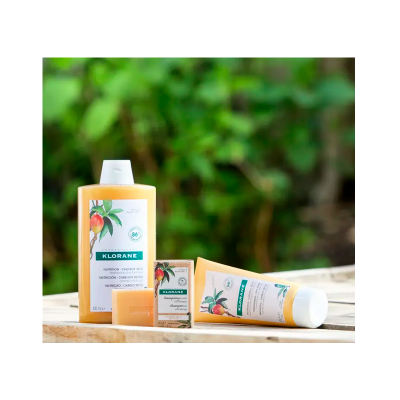 Produtos Klorane com ilustração de pêssegos sobre balcão de madeira