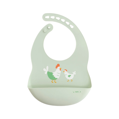 Babete de silicone verde claro com galinhas desenhadas e bolso para recolher comida.