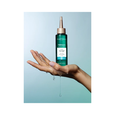 Frasco verde do Sérum Triphasic Active Grow sobre mão molhada