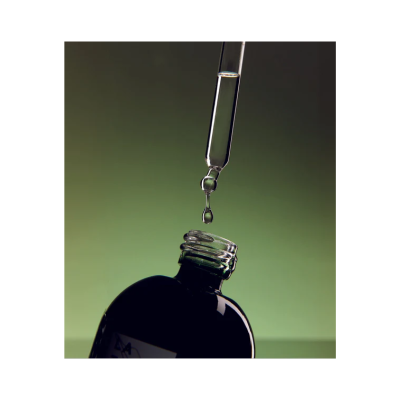 Frasco de vidro escuro com conta-gotas a deixar cair gota