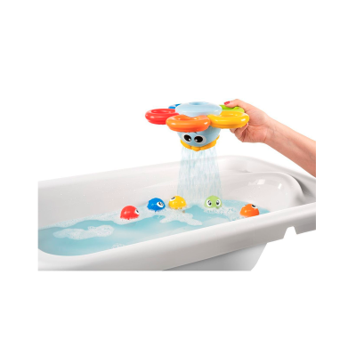Brinquedo de banho em forma de flor a jorrar água sobre peixinhos coloridos numa banheira.
