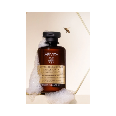 Frasco de champô APIVITA com espuma e abelha próxima