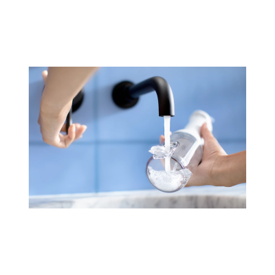 Dispositivo de vidro a receber água de uma torneira preta junto a azulejos azuis