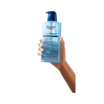 Frasco de gel de banho Eucerin azul segurado por uma mão