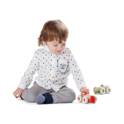 Criança a brincar com carrinhos de madeira coloridos em fundo branco