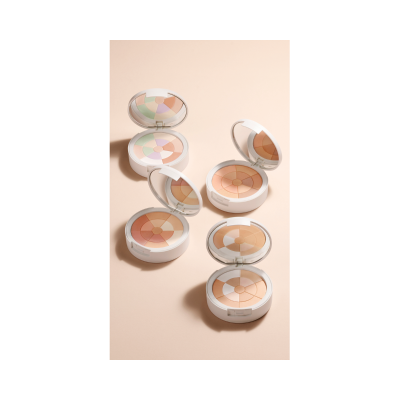 Cinco estojos de maquilhagem redondos com pós compactos de várias cores pastel e neutras