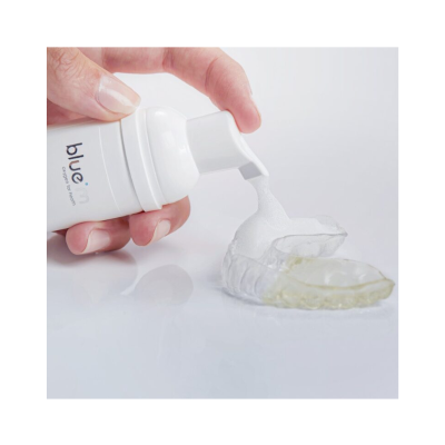 Frasco branco blue A a aplicar espuma em aparelho dentário transparente