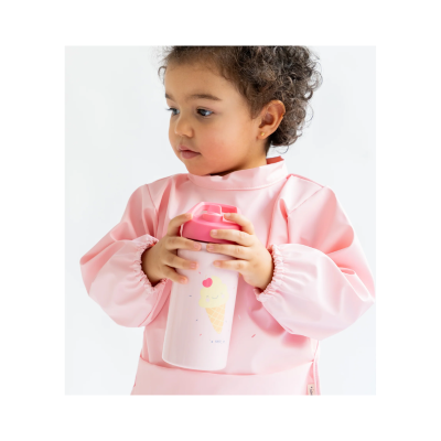 Criança com bata rosa segurando copo térmico branco com tampa rosa e desenho de gelado