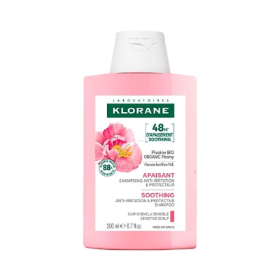 Frasco rosa de shampoo Klorane com rótulo branco e peónia