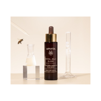 Frasco soro capilar APIVITA Royal Jelly Elixir com béquer e tubo medidor em fundo bege