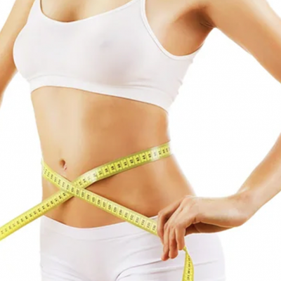 Mulher com roupa interior branca medindo a cintura com fita métrica amarela