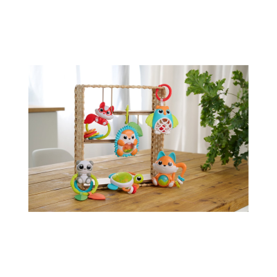 Brinquedos de bebé coloridos com figuras de animais expostos numa estrutura e numa mesa de madeira