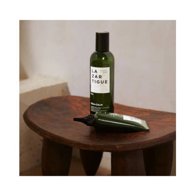 Dois frascos verdes de plástico com etiquetas brancas e texto LAZARTIGUE e CICA-CALM sobre mesa de madeira escura