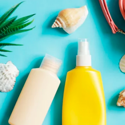 Dois frascos de plástico com conchas e folhas sobre superfície azul.