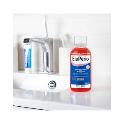 Garrafa de EluPerio 300 ml com líquido vermelho num lavatório branco