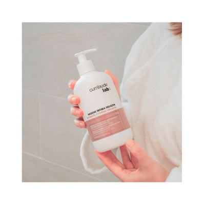 Frasco branco de gel para higiene íntima com doseador, etiquetas rosa e texto em português e inglês.