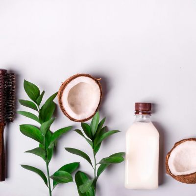 pente, cocos cortados, garrafa de vidro com líquido branco, ramos verdes