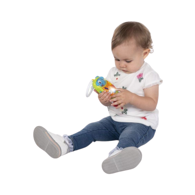 Bebé com camisola branca e calças azuis a segurar brinquedo infantil colorido