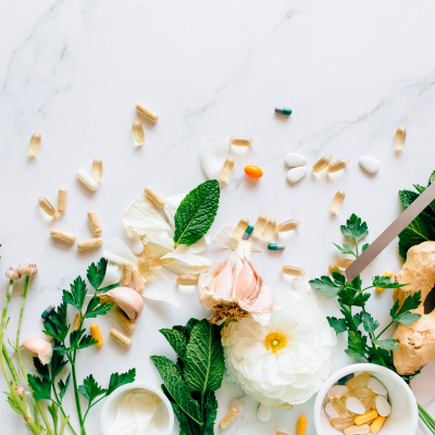 Suplementos e plantas naturais sobre bancada de mármore clara