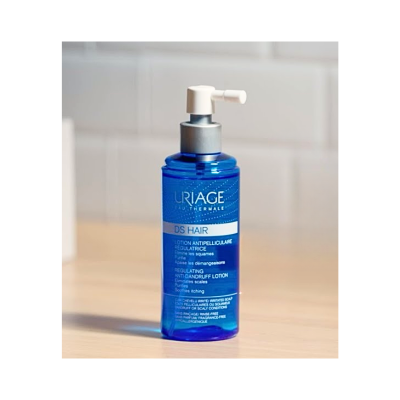 Frasco azul de loção anti-caspa Uriage DS Hair com doseador branco