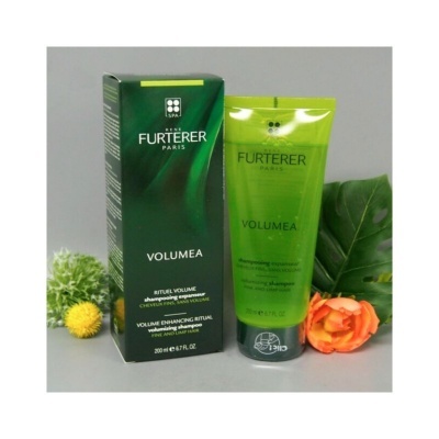 Champô volumizador Rene Furterer Paris Volumea com caixa e tubo verdes, rodeado por flores e folhas.