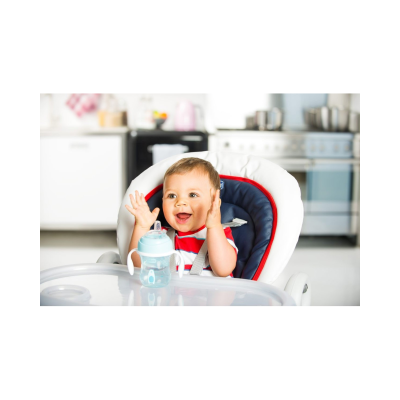Criança numa cadeira alta com carrinho azul branco e vermelho a sorrir, mamadeira azul clara sobre a bandeja branca.