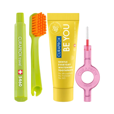Conjunto de higiene oral com escova de dentes verde, pasta dentífrica amarela e fio dental rosa