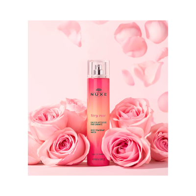 Perfume NUXE Very rose em vidro rosa com rosas cor-de-rosa ao redor