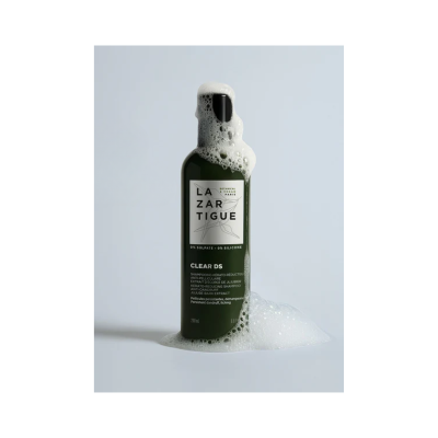 Frasco verde escuro de champô LAZARTIGUE CLEAR DS com espuma branca e rótulo branco com texto preto