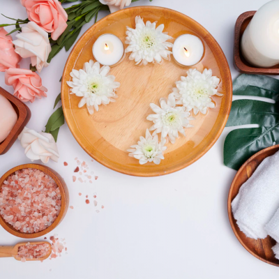 Itens para spa com flores, velas, sal grosso e toalhas em fundo branco