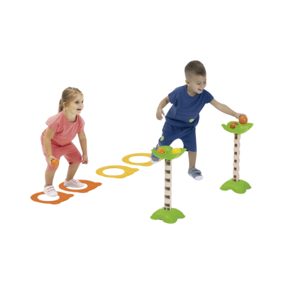 Crianças a brincar com brinquedo de lançamento de bolas, bases verdes, postes castanhos, bolas laranja e amarela, tapetes com círculos coloridos.