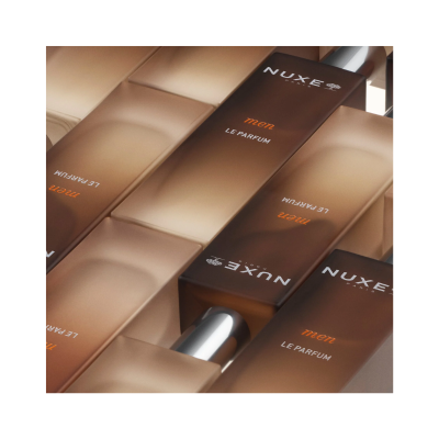 Frascos de perfume NUXE Paris men LE PARFUM castanho com tampa prateada sobre superfície bege