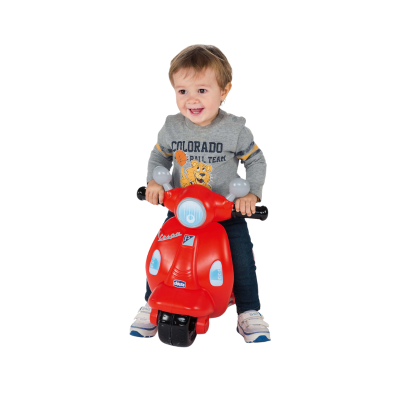 Criança numa mota de brinquedo vermelha com texto Vespa e Chicco