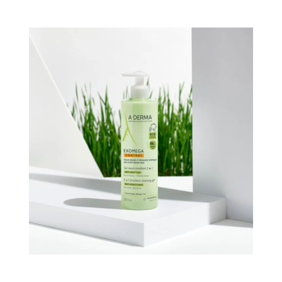 Gel lavante A-DERMA EXOMEGA CONTROL em garrafa verde com doseador branco sobre suporte branco e relva ao fundo