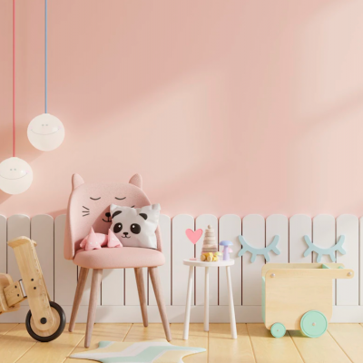 Cadeira rosa com almofadas de gato e panda em quarto infantil decorado com brinquedos de madeira e candeeiros sorrisos