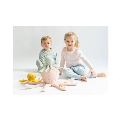 Dois crianças sentadas com peluches polvos coloridos em fundo branco