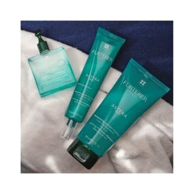 Produtos FURTERER verdes sobre tecido azul e branco