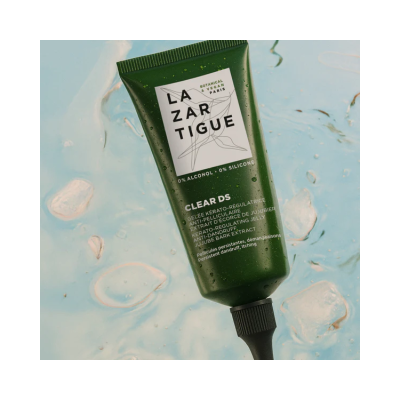 Frasco verde de gel capilar Lazar Tigue Clear DS sobre fundo azul com gelo