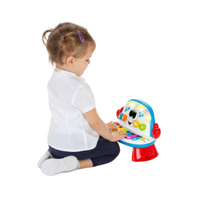 Menina sentada a brincar com piano de brinquedo colorido e luzes