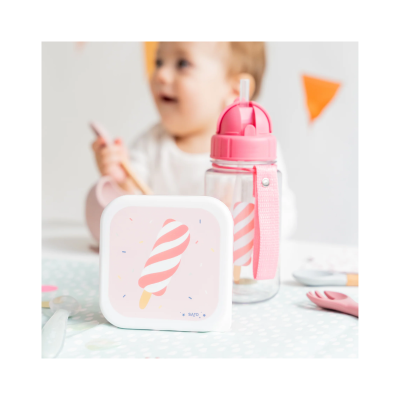 Lancha e garrafa cor-de-rosa com padrão de gelado às riscas, utensílios infantis e criança desfocada ao fundo