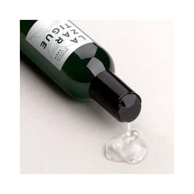 Frasco verde com tampa preta a verter líquido transparente.