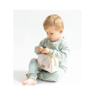 criança vestindo roupa verde água segurando bolsa branca com padrão colorido