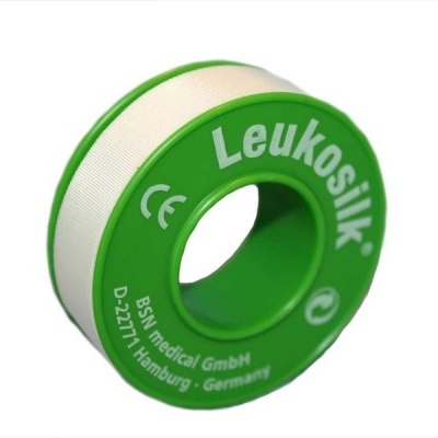 Rolo de fita médica branca LeukoSilk com carretel verde.
