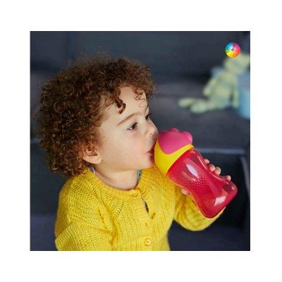 Criança a beber de um copo infantil vermelho e amarelo