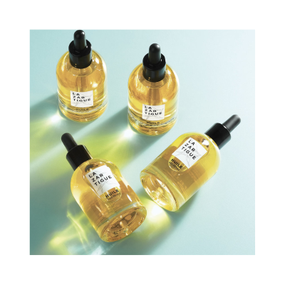 Frascos de vidro com pipetas e óleo amarelo sobre superfície azul