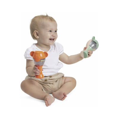 Bebé sorridente com chocalhos laranja e verde em fundo branco.