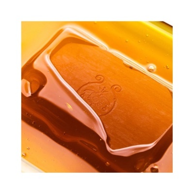 Bloco de resina âmbar com padrão circular em líquido amarelo-transparente