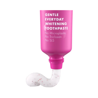 Tubo rosa de pasta de dentes a abrir com pasta branca com granulados vermelhos